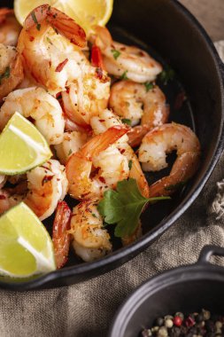 Tavada sarımsaklı sebzeli ızgara karides.