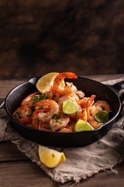 Tavada sarımsaklı sebzeli ızgara karides.