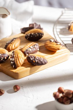 Vanilla madeleine cookies with chocolate and nuts clipart