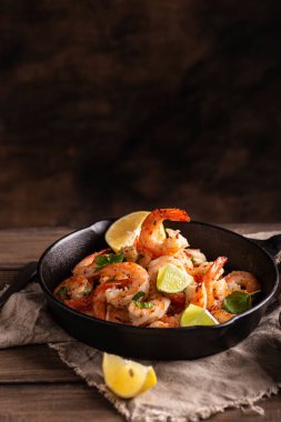 Tavada sarımsaklı sebzeli ızgara karides.