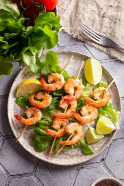 Freshly cooked grille shrimps with letucce on a plate