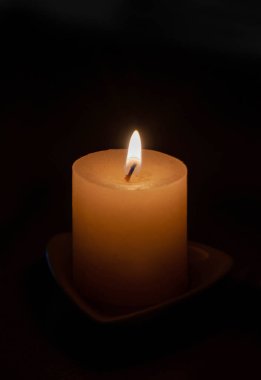 Karanlıkta yanan bir mum. Uzayı kopyala..