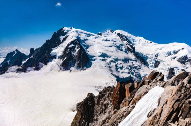 Avrupa, Fransa. Mont Blanc 'ta güneşli bir yaz günü. Karla kaplı dağlar. Beyaz bulutlu mavi gökyüzü. Batı Alpleri. Uzayı kopyala.