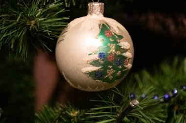 Üzerinde Noel ağacı olan gümüş bir Noel süsü.