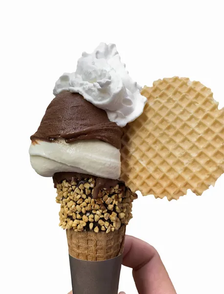 Italian chocolate-vanilla-cream ice cream (gelato) sprinkled with shredded nuts and decorated with a huge wafer held in the hand of a young man. Isolated on a white background. Italian cuisine. Gourmet dessert.