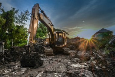Gün batımında çalışan kepçe yükleyici