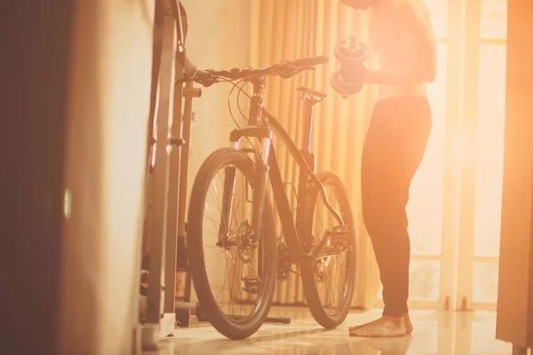 Man Using Dumbbells Wiht Bicycle Home — Stockfoto