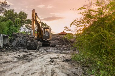 Gün batımında kaldırılmış kovayla bir kepçe
