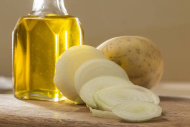 Arka planda soğan, patates ve yağ var.