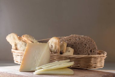 Kahvaltı hazırlıyorum, dilimlenmiş peynir ve çeşitli ekmekler.