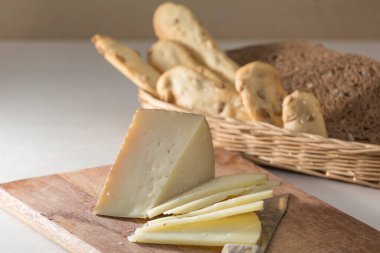 Kahvaltı hazırlıyorum, dilimlenmiş peynir ve çeşitli ekmekler.