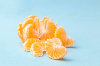 Mandalina kabuğu soyulmuş, mavi arkaplana yerleştirilmiş.