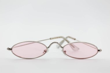 Beyaz arka planda izole edilmiş pembe lensli gözlüklerin yakın çekimi