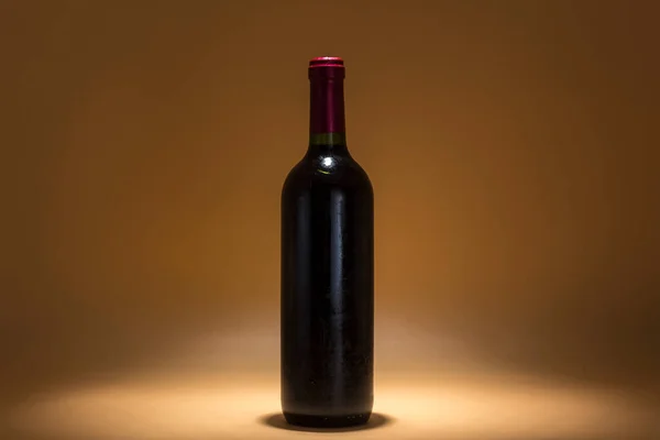 Вид Одинокой Бутылки Красного Вина Коричневом Фоне Интимное Освещение Создающее — стоковое фото