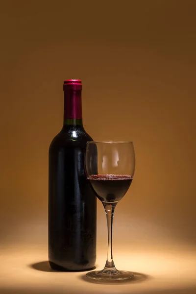 Вид Бутылки Красного Вина Бокала Содержащего Жидкость Помещенного Теплом Фоне — стоковое фото