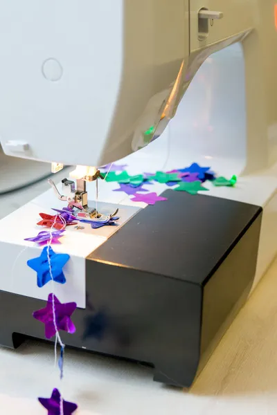 Noel dekoru için çok renkli parlak konfeti yıldızlarının el yapımı çelenkleri.