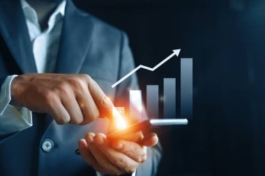 Businessman touching smartphone screen.Technology digital concept.Chart trading growth.