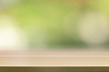 Boş ahşap masa, yeşillik bahçesi arka planında boş alan.