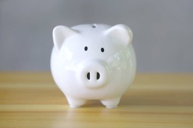 Seramik domuz kumbarası ahşap masada..