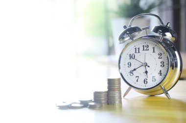 Alarm saati ve ahşap masa üzerindeki bozuk para yığını. Çevrimiçi alışveriş konsepti..