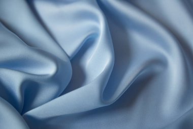 Maviyle örtülmüş güzel ipek kumaş. Saten kumaş dalgalarının arka planı