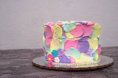 Pasta spatulayla süslenmiş. Çimento masasında renkli pasta.