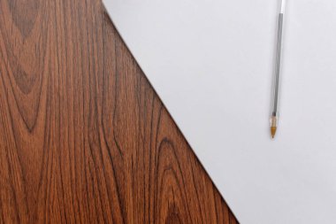 Ahşap masadaki boş kağıt üzerine kalem..