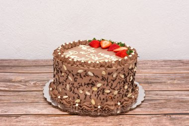 Çilekli çikolatalı pasta. Tahta masada nefis ev yapımı çikolatalı pasta.