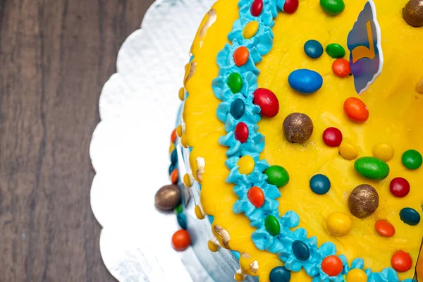 お菓子で飾られたカラフルなケーキ 木製のテーブルの上に青と黄色のケーキ トップ表示 — ストック写真