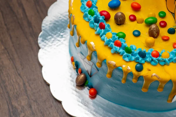 Lunette 'lerle süslenmiş renkli pasta. Ahşap masada mavi ve sarı pasta. Üst görünüm.