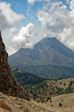 Meksika 'da Colima Volkanı. Colima volkanının gündüz manzarası. Mavi gökyüzü ve beyaz bulutlar..