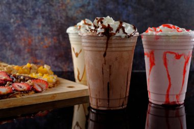 Malt milkshake, farklı aromalı ve koyu arkaplanda krep..