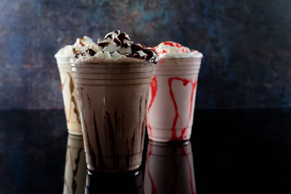 Koyu arkaplanda farklı aromalı milkshake.