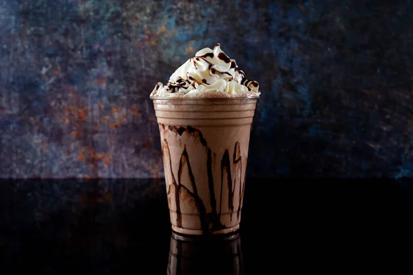 Çikolatalı milkshake, siyah arka planda berrak bir bardakta servis edilir. Ayrı bir içecek..