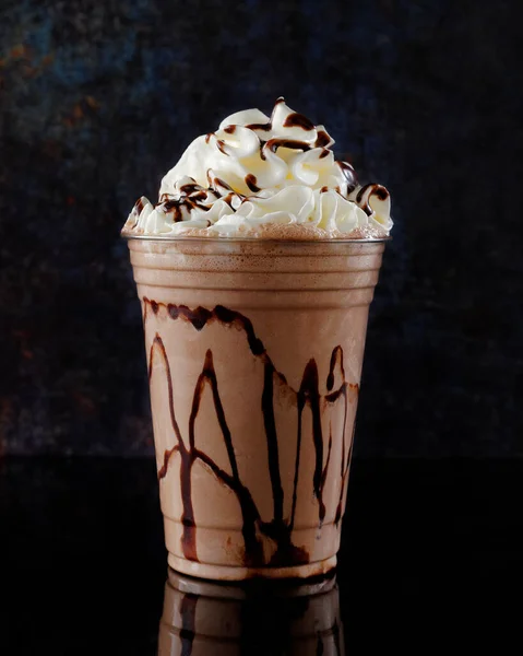 Çikolatalı milkshake, siyah arka planda berrak bir bardakta servis edilir. Ayrı bir içecek..