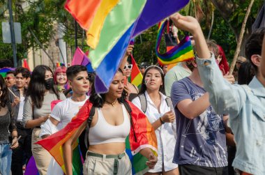 Colima, Colima / Meksika; Temmuz 03, 2022: İnsanlar çok renkli bayrakları sallayarak LGBT + Gurur Yürüyüşünü kutluyorlar.