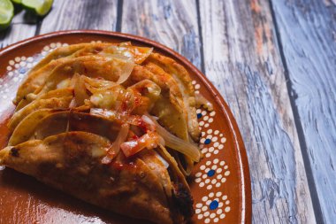 Barbacoa tacoları ahşap bir masada kil bir tabakta servis edilir. Tipik Meksika yemekleri..