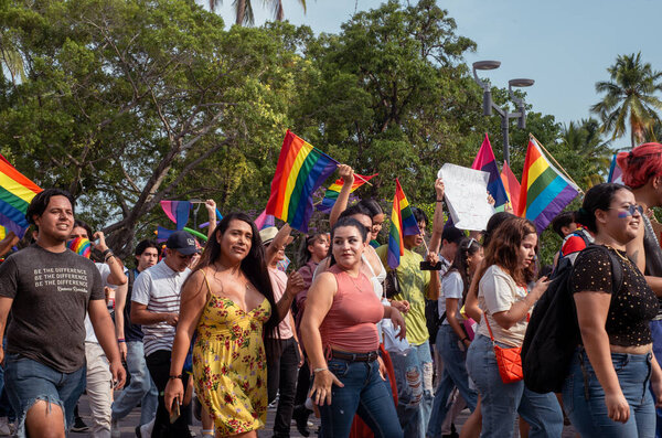 Колима, Колима. Мексика; 03 июля 2022 года: Люди, празднующие парад ЛГБТ + Гордость размахивают разноцветными флагами.