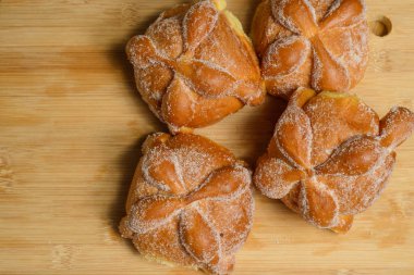 Pan de muertos on a wooden table. Typical Mexican dessert for the Day of the Dead. Top view.