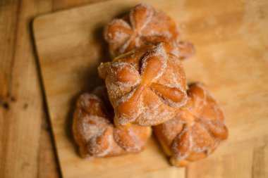 Pan de muertos on a wooden table. Typical Mexican dessert for the Day of the Dead. Top view.