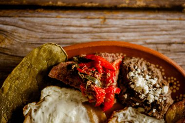 Huevos rancheros, et, fasulye, nopal ve kir içinde kızarmış muz. Tipik Meksika yemekleri..