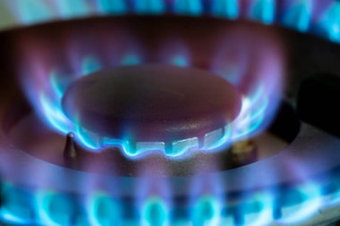 Gaz ocağının ocağında mavi alevlerle yanıyor. Piyasadaki karbon ayak izi ve doğal gaz fiyatı kavramı. Yakın çekim.