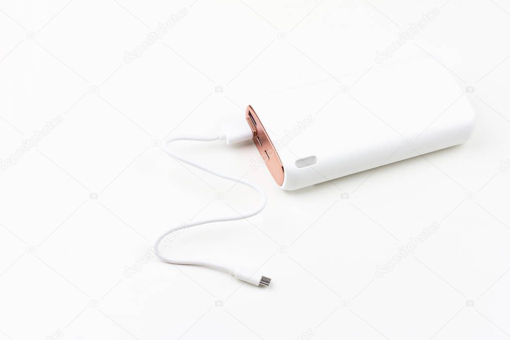 white power bank for charging smartphones and various digital devices on a white background close-up
