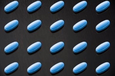 Bir şablon oluşturmak için düzenlenmiş mavi haplar. Mavi haplar erkek ereksiyon bozukluğu konsepti