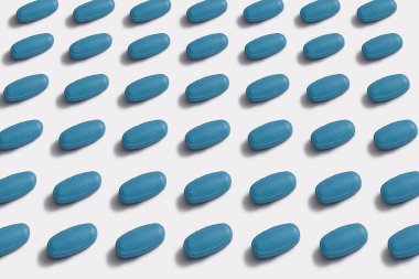 Ordered pattern of blue tablets on white background clipart
