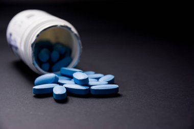 Ön plandaki mavi haplar bulanık arkaplandaki beyaz plastik kutudan çıkıyor.