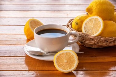 Beyaz fincanda limon sade kahve ahşap masada taze limon limon sade kahve sağlıklı bir içecektir..