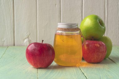 Şişede elma suyu, sağlıklı içecek, ahşap zeminde kırmızı ve yeşil elma meyveleri, kopyalanmış organik yiyecekler..