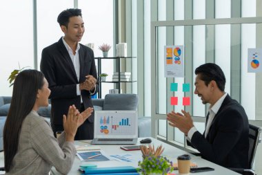 Genç Asyalı girişimciler iş ağlarıyla uzaktan sohbet ederken bilgisayarlarına bakarlar..