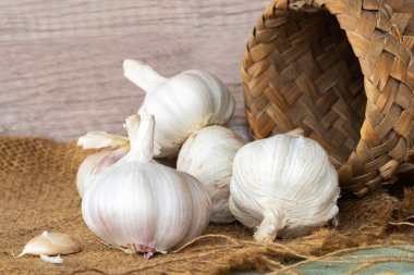 Sarımsak ampulleri (Allium sativum) çuval vintage arka planda. Sarımsak kan yağ oranını düşürür.